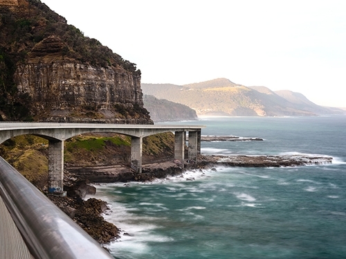 a road that is elevated over a beautiful seaside landscape